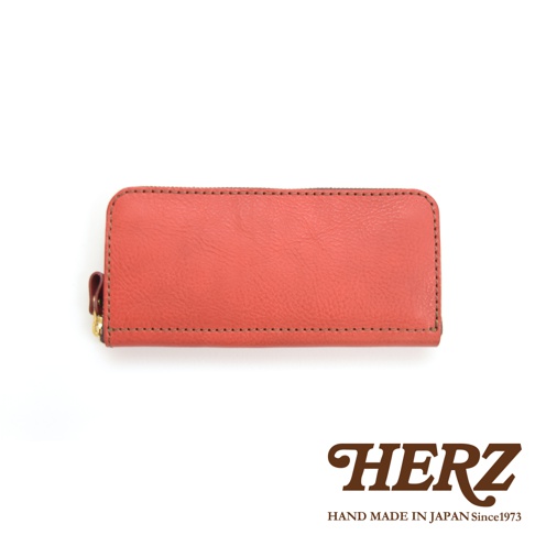 職人手作皮革經典拉鍊長夾，採用珊瑚橘色皮革，配有金色拉鍊與皮革拉頭，車縫線清晰，整體簡潔大方。