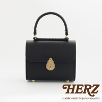 黑色皮革復古杜勒斯手提包，配有金色鎖扣和提把。包包底部有四個金色金屬腳釘。