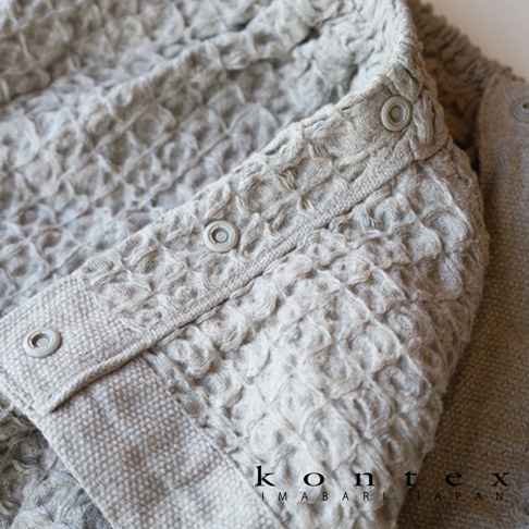 淺灰色格紋平口浴裙，附有按扣，搭配同色系抗菌髮帶，整體為純棉材質，觸感柔軟。