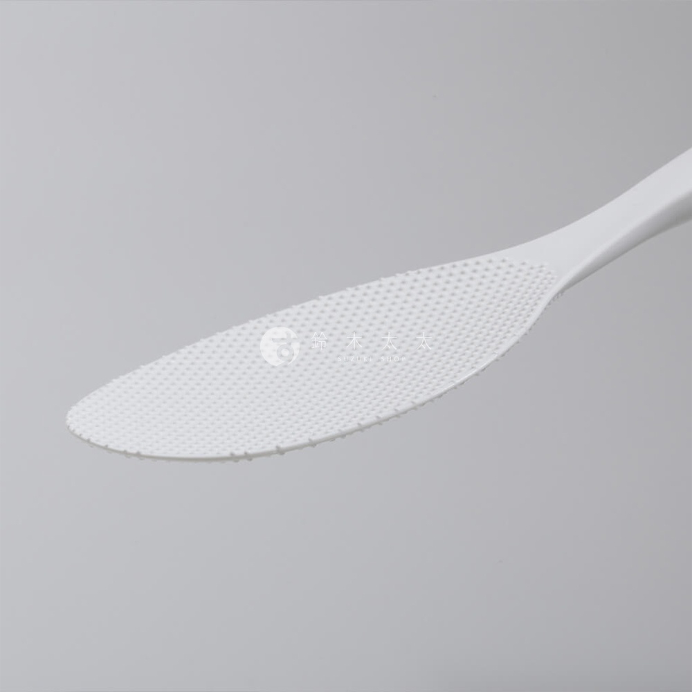 日系站立式好握飯匙，白色塑膠材質，表面有防沾黏米飯的細小顆粒壓紋，手柄處有品牌標誌。