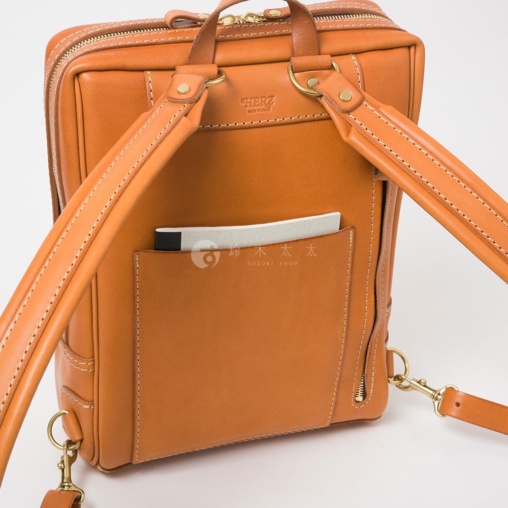 職人手作皮革軟皮商務後背包 R-28，採用溫潤的棕褐色皮革，搭配簡潔的縫線設計，呈現經典質感。後背包背面設有方便收納的 открытый карман，可放置筆記本等物品，展現實用機能。