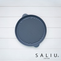 深藍色圓形陶製烤盤，表面有明顯的平行烤紋，兩側有握把。