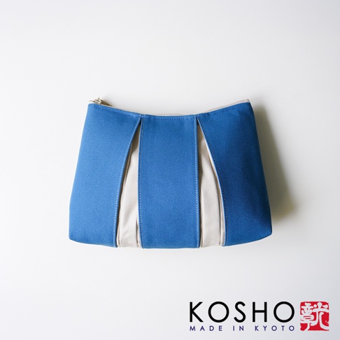 這款京都KOSHO ougi帆布化妝收納包L採用簡約設計，藍色與米白色帆布交錯拼接，包身呈現出優雅的折疊立體感，整體風格清新自然，適合收納日常化妝品或隨身小物。