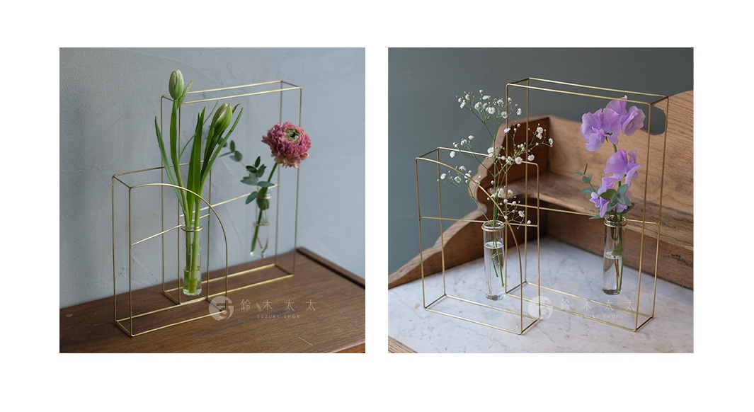 黃銅線條構成的現代簡約花架，有大小兩個隔間，每個隔間內置玻璃試管花瓶，分別插有綠葉、粉紅色花朵、白色小花及紫色花朵。
