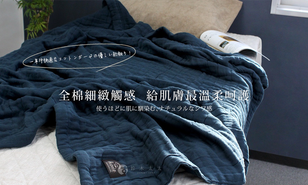 深藍色八層紗棉質透氣被，材質輕柔，表面有細緻的菱形格紋絎縫，散發自然舒適的氣息。