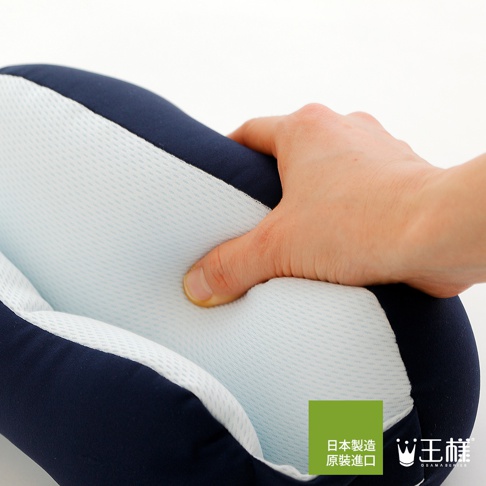 深藍色與淺藍色網眼布料拼接的舒眼枕，一隻手正按壓其柔軟的填充物，展現產品的舒適觸感。