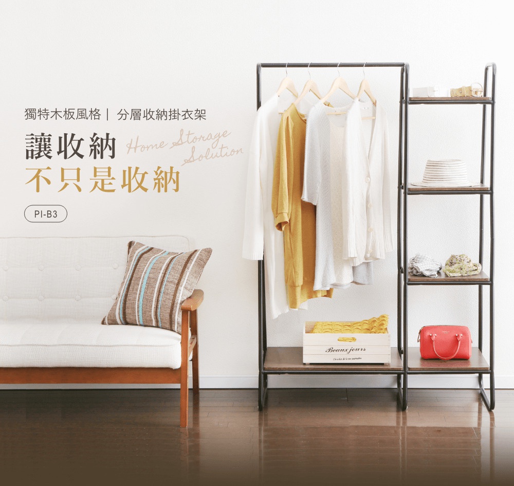 木板風格分層收納吊掛衣架，黑色金屬框架搭配木紋層板，掛有白色、黃色、淺灰色衣物，右側層板有草帽、毛巾、紅色包包和木箱。