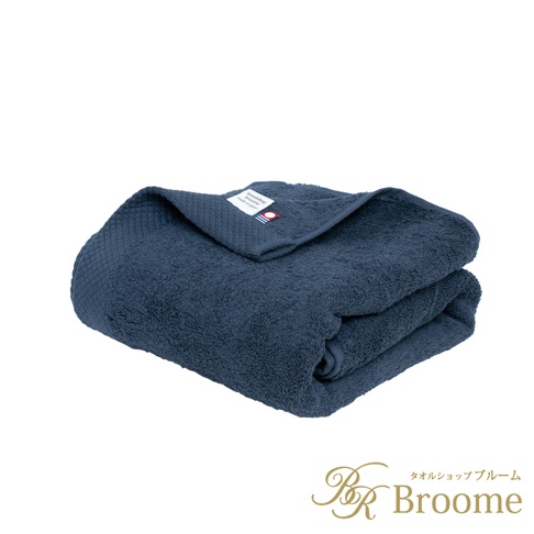 深藍色今治純棉長浴巾，表面有菱紋織法，質地柔軟，標籤顯示品牌名稱。
