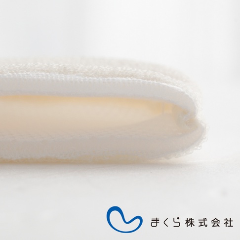 白色蠶絲洗臉手套，材質柔軟，邊緣有縫線，呈現輕柔的質感。