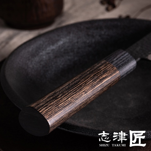 玄 / Chef's knife 主廚刀24cm，刀柄為深棕色木紋材質，與黑色刀身和黑色刀盤形成對比。