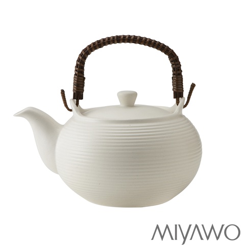 白色陶土茶壺，壺身有橫向紋路，搭配編織藤條提把，附有壺蓋和茶嘴。