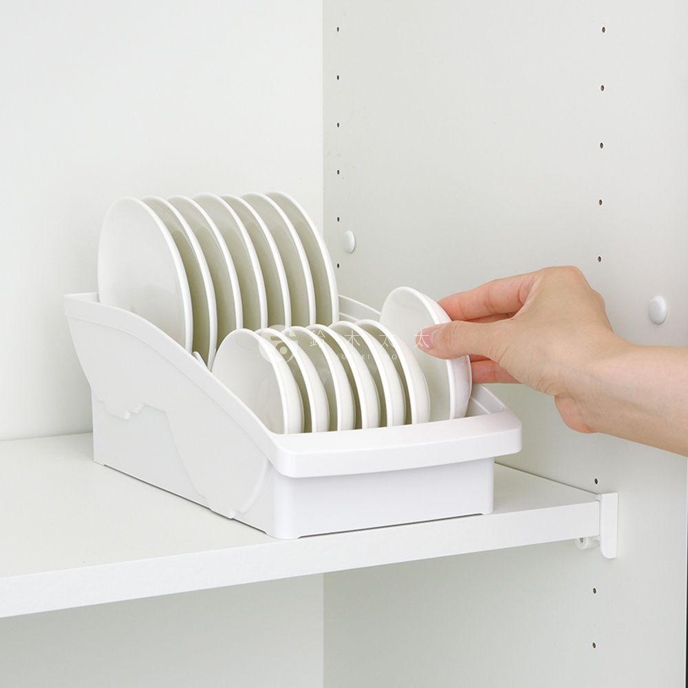 白色塑膠碗盤瀝水架，可收納多個盤子和碗，一隻手正在放入一個盤子。