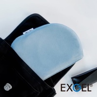 THE OWL 進階款隨身坐墊，淺藍色，柔軟織物表面，呈現半圓弧形，置於黑色包袋中，旁邊為黑色皮質小物。