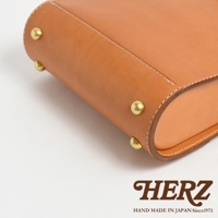 職人手作皮革杜勒斯商務後背包 BJ-10，展示了棕色皮革的細緻質感，搭配黃銅鉚釘和白色縫線，展現簡約的商務風格。