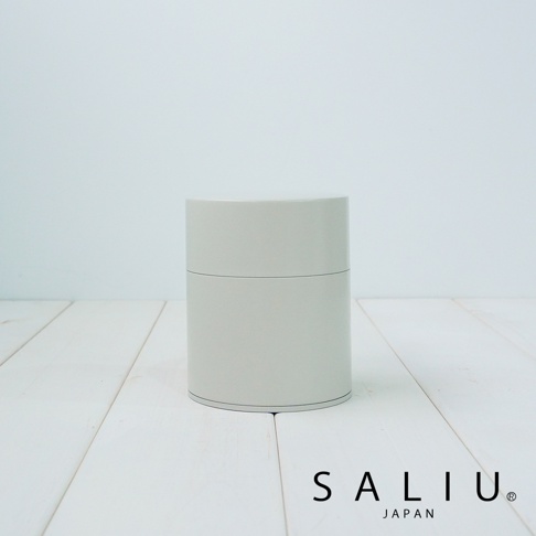 淺灰色圓柱形錫製茶葉罐，罐身簡約無裝飾，頂部有蓋子，罐身中央有一條細線分隔，底部有品牌標誌 SALIU JAPAN。