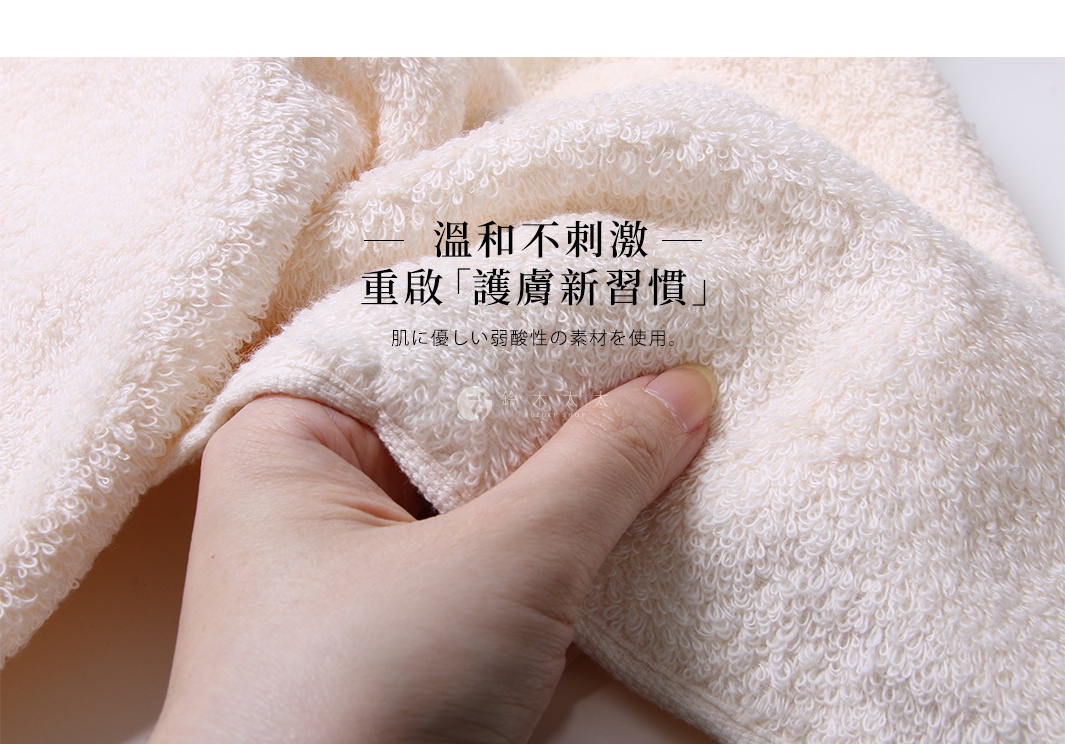 一塊米白色、觸感蓬鬆的長毛巾，其細緻的毛圈織法清晰可見，一隻手正輕柔地觸摸著毛巾的質地，展現其柔軟舒適的特點。