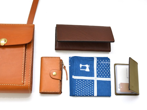 職人手作皮革厚實單肩包 (CP-61) 側面，包含一個棕色皮革長夾、一個棕色皮革零錢包、一個藍色印花布，以及一個綠色皮革名片夾。
