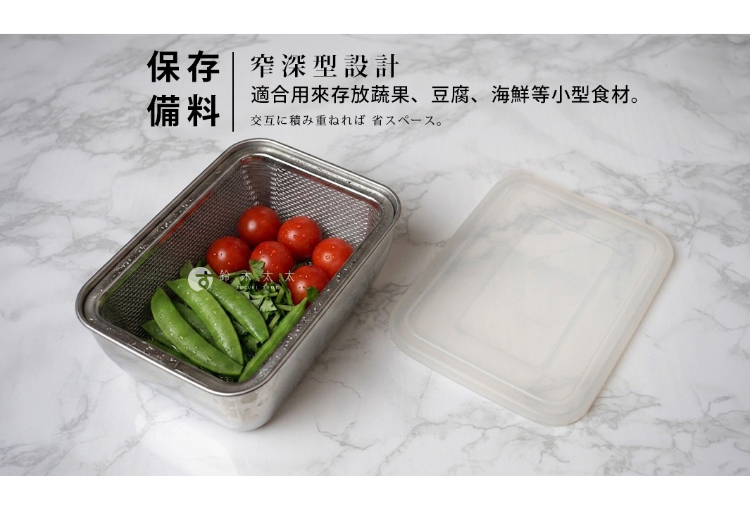 一張俯視視角的產品照片，主體為一個銀色不鏽鋼長方形調理保存盒，內部裝有櫻桃番茄與四季豆等蔬果，盒身內部設有濾網籃設計。保存盒右側擺放著一個透明半霧面塑膠蓋。背景為淺色大理石紋理檯面，上方標題提及此為窄深型設計，適合存放小型食材並可疊加節省空間。