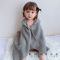 一名嬰兒身著灰色針織連帽浴巾，浴巾採用純棉材質，帶有羅紋邊緣。