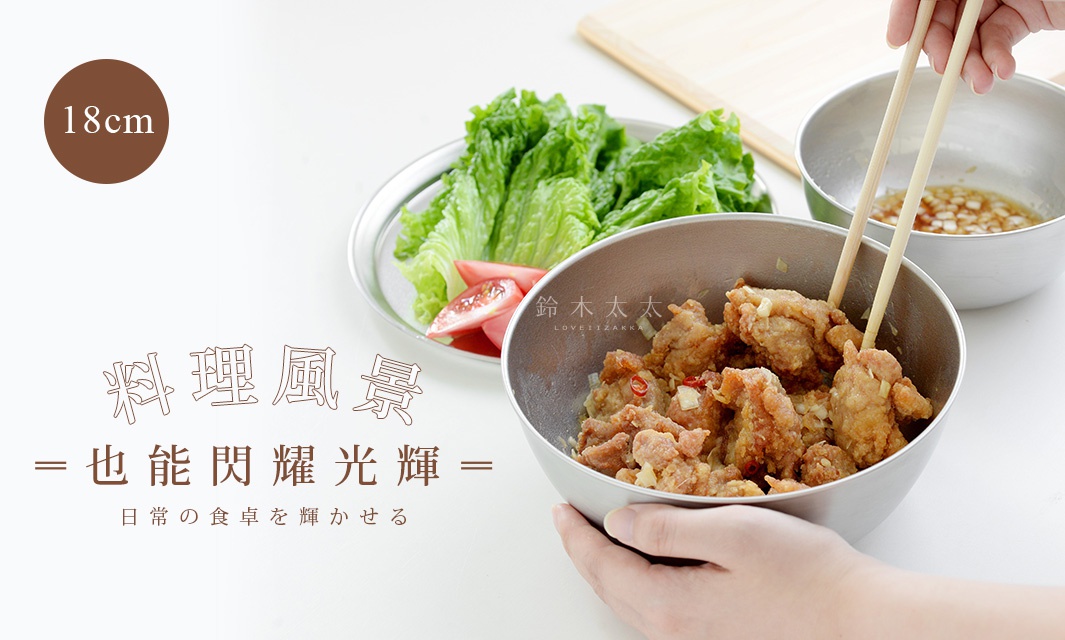 一個不鏽鋼調理碗，盛裝著炸雞塊，有筷子夾取；旁邊另一個不鏽鋼碗裝有醬汁，另一盤中擺放著生菜和番茄。