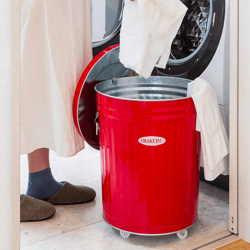 OBAKETSU 品牌手工製附輪紅色 33 公升垃圾桶，裝有白色衣物。