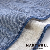 今治復古丹寧風雙織柔感浴巾，織紋雙面設計，一面為藍色丹寧風格織紋，另一面為米白色毛圈織紋，邊緣有藍色滾邊及紅色縫線。