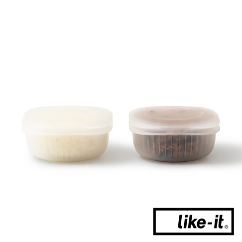 兩個簡約雙層蒸氣循環保鮮盒，一個裝有淺色食物，另一個裝有深色穀物。保鮮盒為半透明的圓形設計，配有透明蓋子。