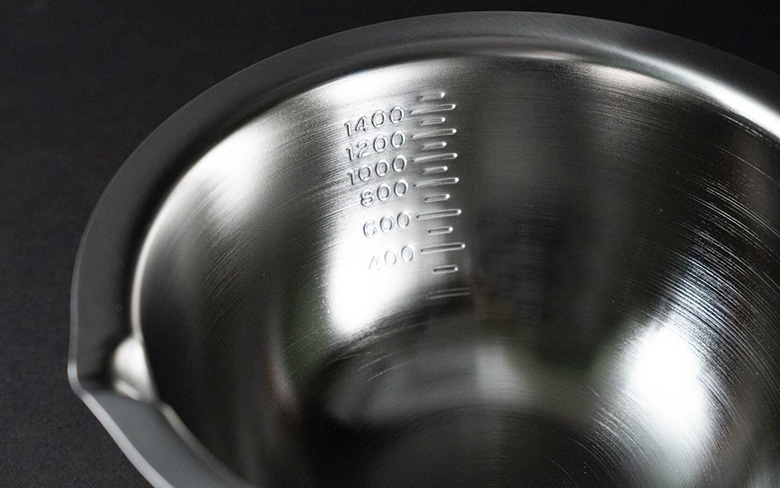 不鏽鋼料理盆，內側有壓印的刻度，顯示 400 至 1400 毫升的容量。盆邊緣有導流設計。