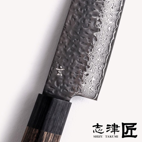 志津匠玄 Nakiri knife 菜切刀 13cm 的特寫，展示了鍛造紋路和 Damascus 鋼的細節，以及刀柄的木紋。