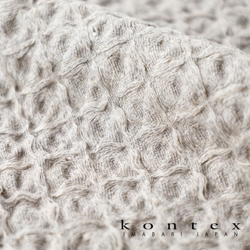 淺灰色棉麻混紡方巾，帶有明顯的鬆餅格紋織紋，材質柔軟，質地清晰可見。