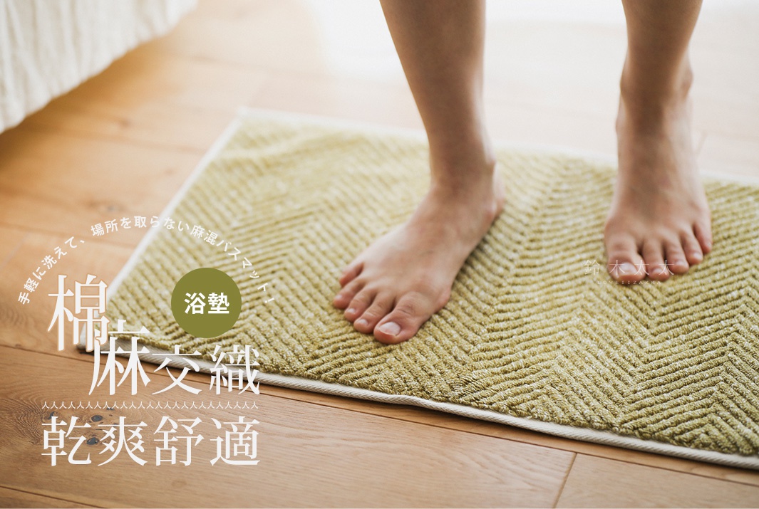 一塊淺綠色棉麻混紡人字紋快乾浴墊，上面有兩隻赤裸的腳。