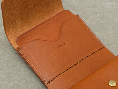 職人手作皮革Organ迷你短夾，咖啡色真皮材質，內有卡槽設計，皮革壓印有「Organ」字樣，縫線整齊。