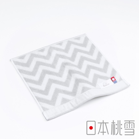 今治北歐方巾，灰色與白色相間的鋸齒形圖案，材質為柔軟的棉，帶有品牌標籤。