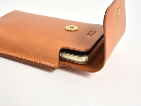 淺棕色皮革手機收納包，帶有壓印標誌和金色按扣，可收納手機。