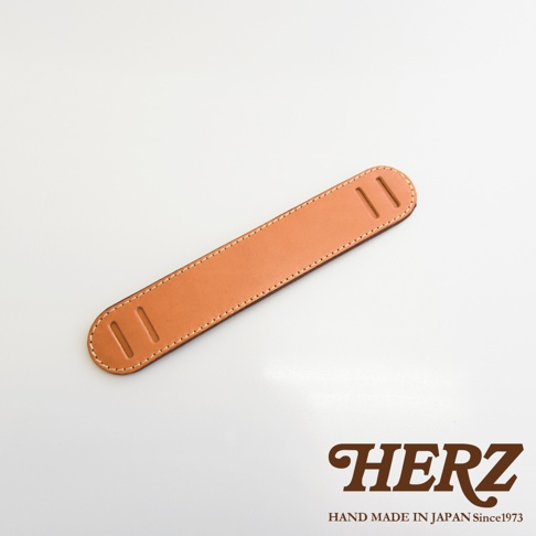 職人手作皮革Big肩墊，淺棕色，帶有縫線和兩個長方形孔洞，適合搭配包袋或樂器。