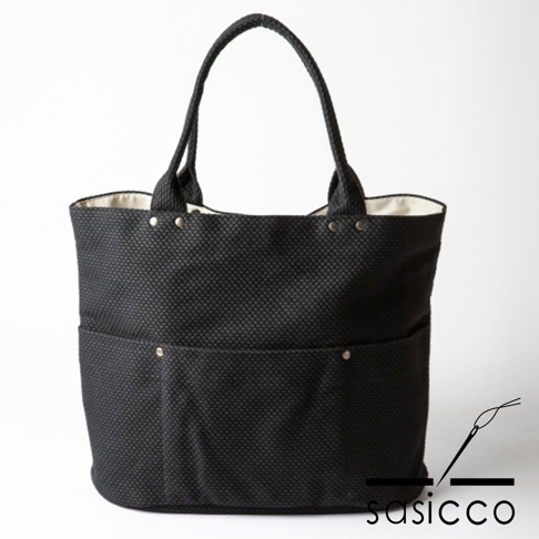 黑色三河木綿刺子織大開口托特包，採用紋理織物材質，設有兩個前置收納袋，配有雙提把，內襯為淺色。