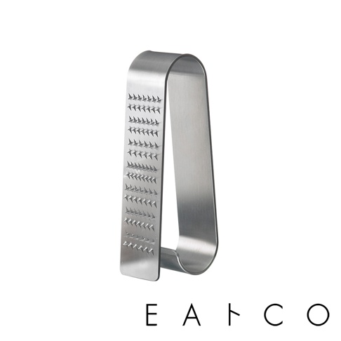 日製立式磨泥器，由不鏽鋼製成，呈現銀色金屬光澤。磨泥器呈U形，一側帶有多排銳利的磨齒，可用於磨細食材。