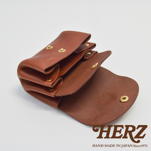 職人手作皮革三層收納零錢包，採用棕色牛皮材質，設有三個夾層和金色按扣，質感細膩，設計簡潔實用。