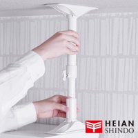 一隻手正在調整白色伸縮防傾桿，此產品由塑膠製成，最大可伸縮至75公分，底部有穩固的底座。