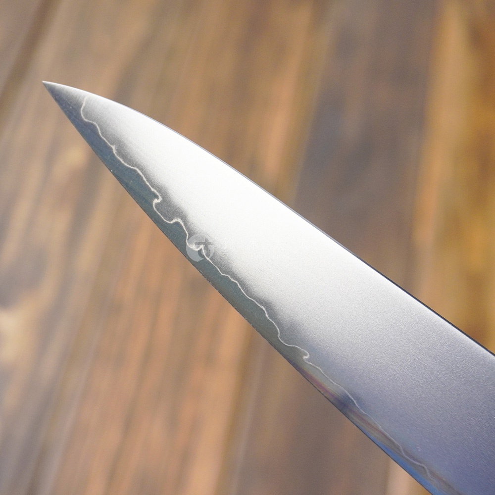 [景清] Chromax鋼水果刀的刀刃特寫，刀刃為銀色Chromax鋼材質，呈現細膩的波浪紋理，刀尖鋒利。