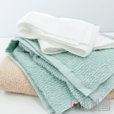 一疊今治細絨浴巾，包含米色、淺綠色和白色，材質柔軟，觸感細緻。