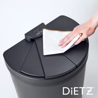 一只手正在用白色布擦拭黑色DustBox30自動感應靜音垃圾桶的頂部蓋板。蓋板為扇形設計，中央有DIETZ品牌標誌和「OPEN/CLOSE」字樣的感應器。