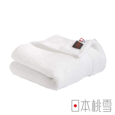 兩條白色今治匹馬棉毛巾堆疊，其中一條毛巾的一角別有「Hotels Grand」品牌標籤，標籤上有法國國旗圖案。