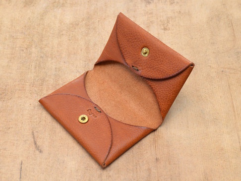 職人手作皮革Organ雙開卡片收納夾，採用棕色皮革製成，具有雙開設計，並以金色金屬按扣固定。內裡為淺棕色皮革。