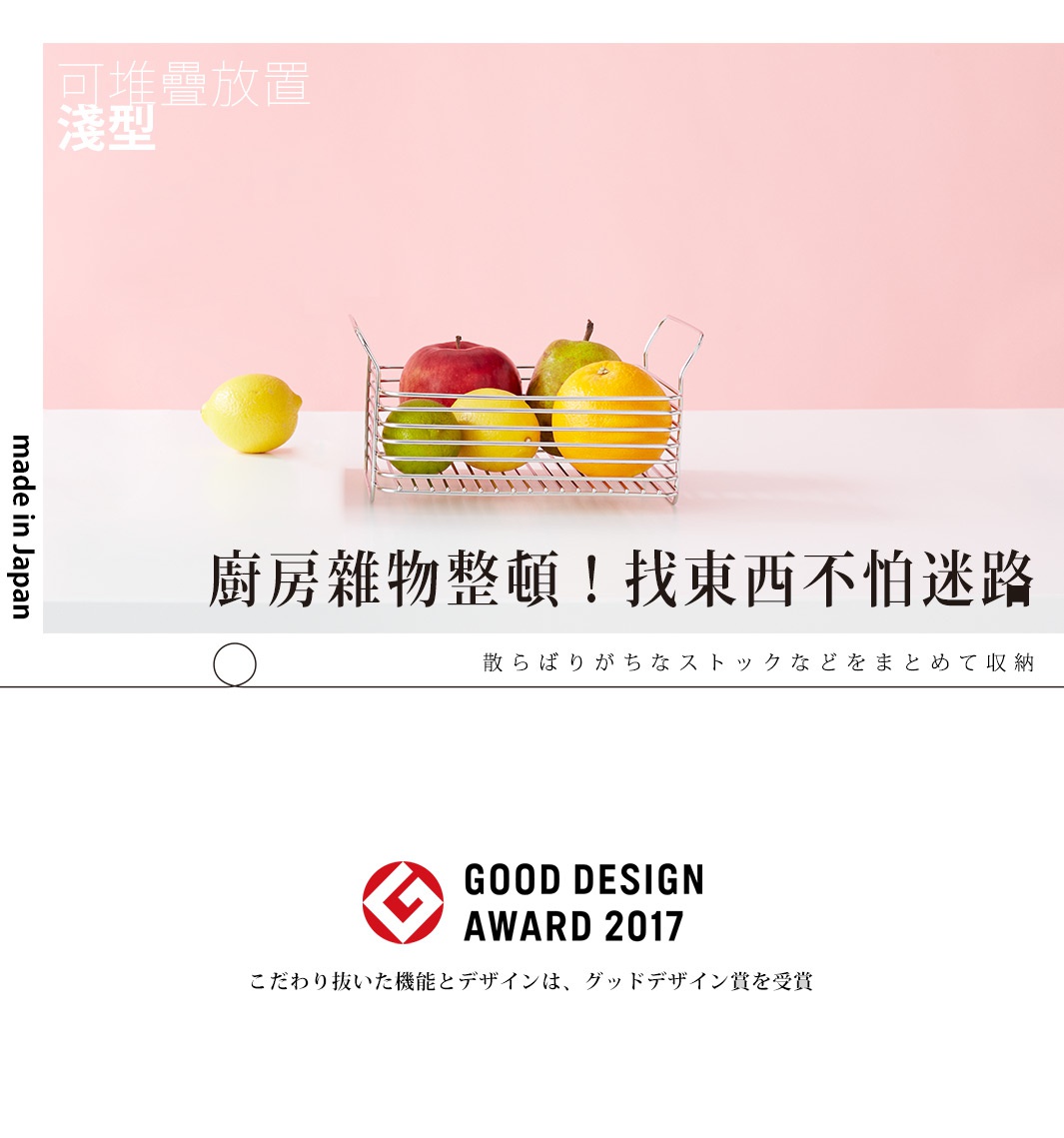 不鏽鋼淺型收納籃內裝有蘋果、檸檬、萊姆和橘子，置於白色桌面上，背景為粉紅色。