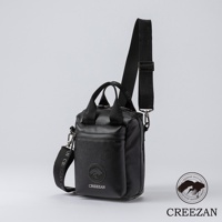 黑色皮革方形側背包，有兩個提把和一條可調式肩帶，肩帶上印有品牌名稱。包包前方有一個拉鍊口袋，上面有品牌標誌。