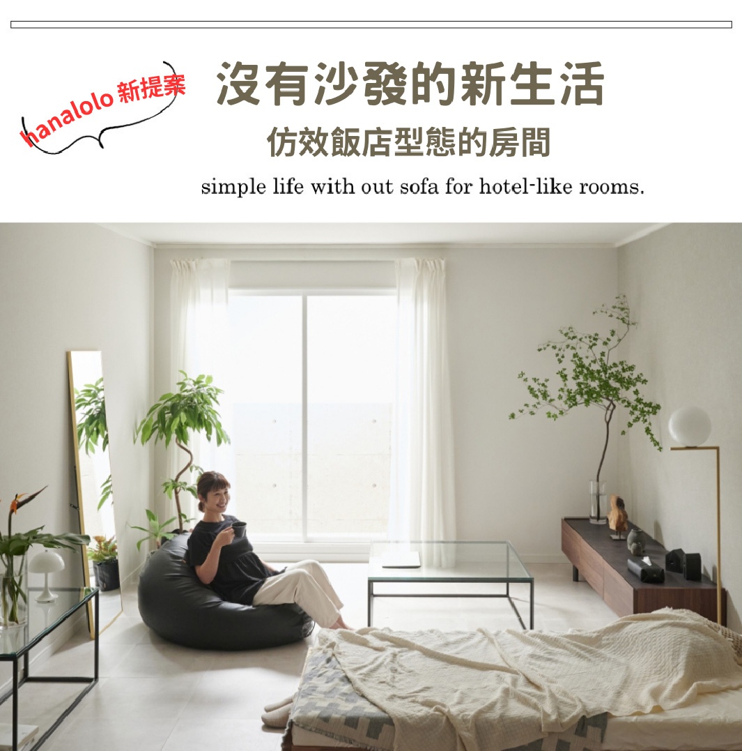 黑色皮革懶骨頭沙發，擺放在簡約風格的客廳中，旁邊有鏡子、綠植、玻璃茶几和床鋪。