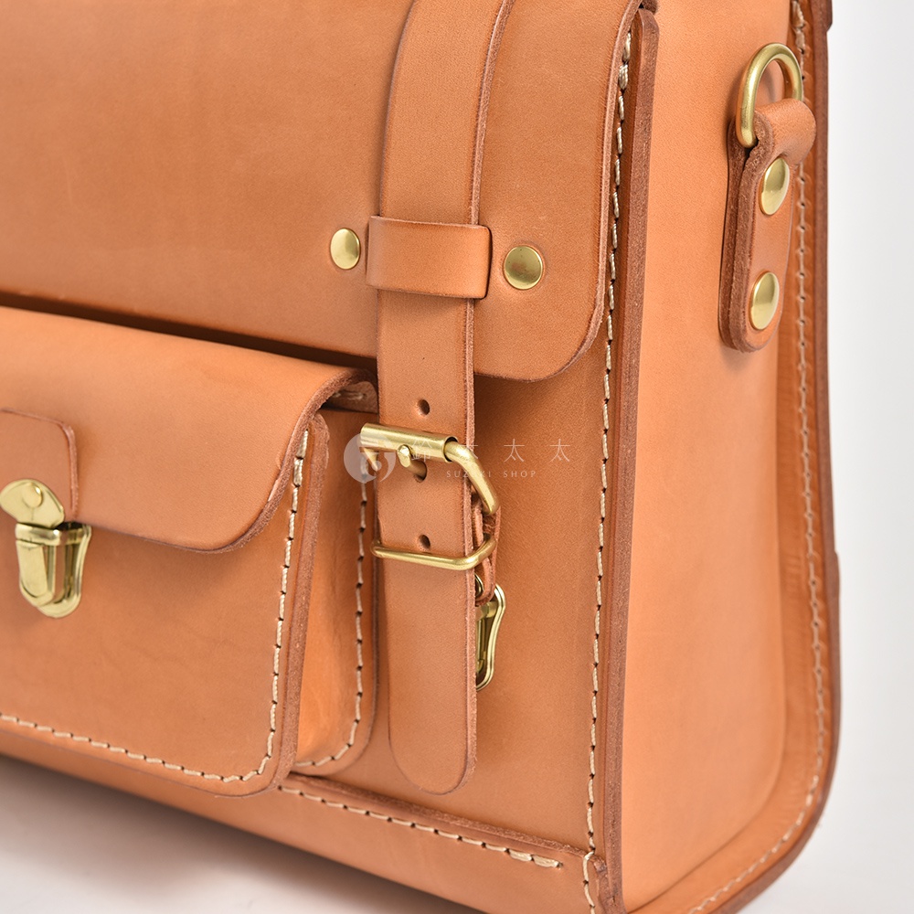 職人手作皮革學院風三用迷你後背包，呈現自然原色皮革質感，配有黃銅色金屬扣環、釦子及調整帶，風格簡約復古。