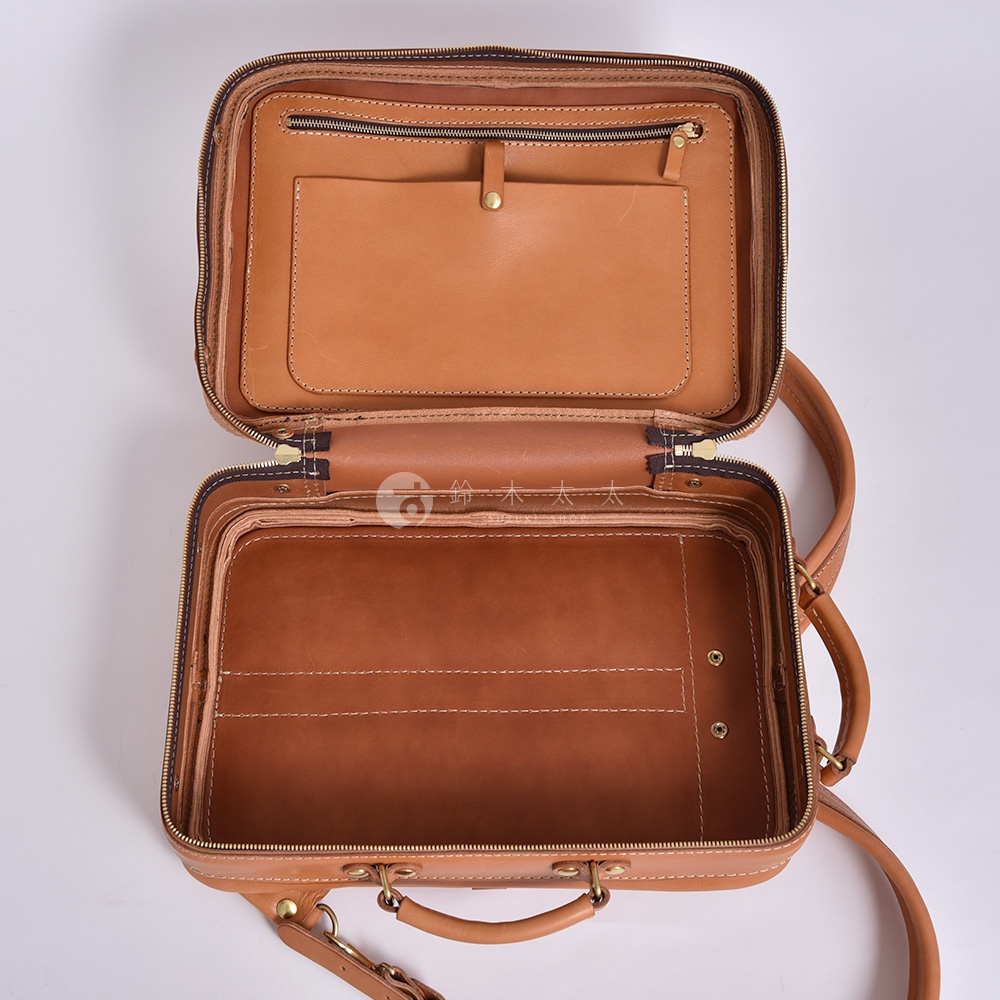棕褐色皮革製成的職人手作兩用商務後背包，打開展示內部隔層，包含拉鍊口袋、開放式口袋及多個隔層，皮革表面有縫線細節，附有提把與背帶。