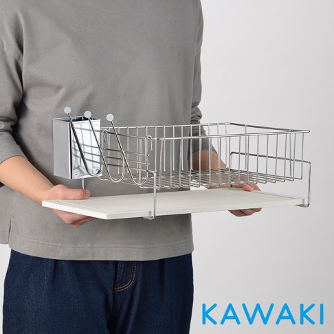 銀色不鏽鋼材質的珪藻土碗盤餐具瀝水架，包含一個餐具收納盒和一個大型瀝水籃，架設於白色珪藻土底盤上，由一人手持展示。